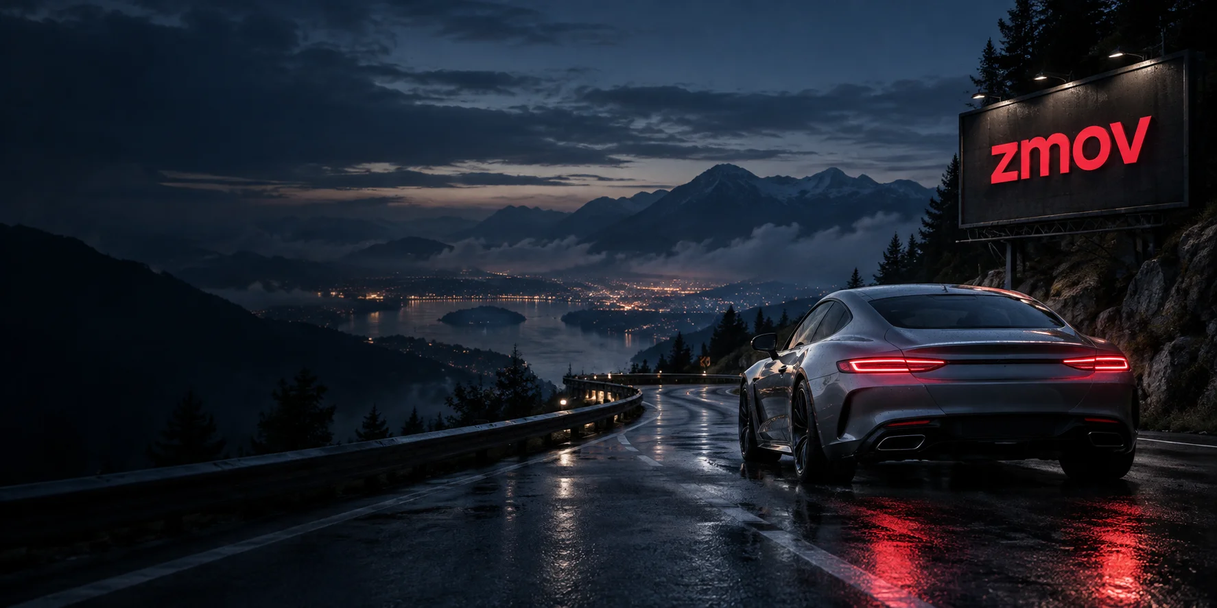 A silver sports car on a mountain road below an illuminated red zmov sign